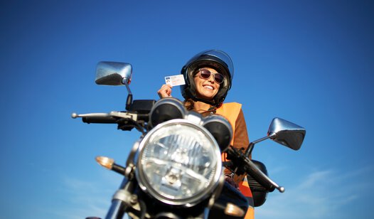 Frau auf Motorrad mit Helm von vorne unten