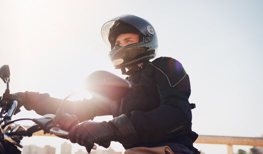 Mann auf Motorrad mit Helm von der Seite