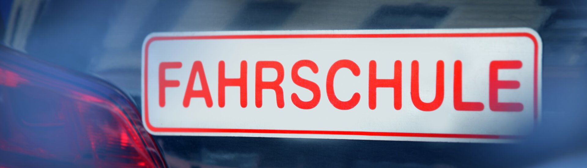 Rotes Magnetschild auf Auto mit Aufschrift Fahrschule