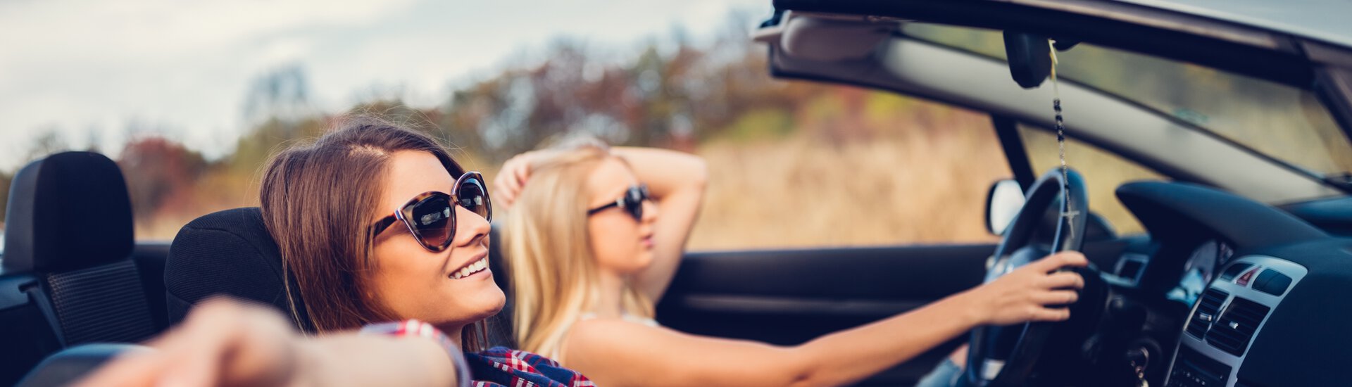 Teenager in Cabrio fahren entspannt durch den Herbst