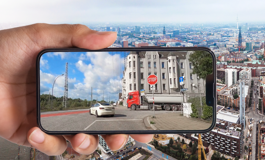 Handy mit DriversCam vor Luftaufnahme von Stadt