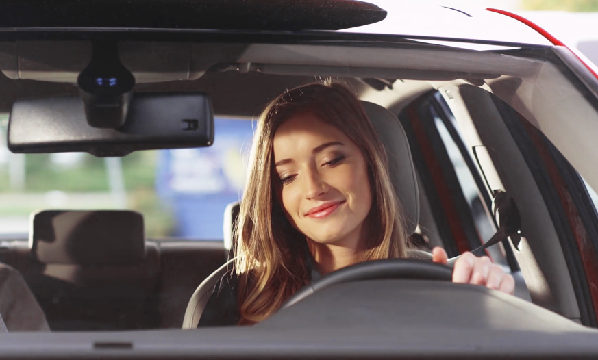 Junge Frau sitz glücklich im Auto