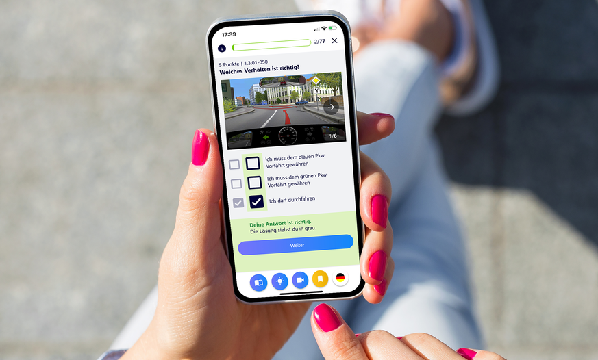 Mit der Fahren Lernen App am Smartphone für den Führerschein lernen Smartphone in Händen mit Fahren Lernen Prüfungsfragen